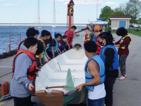 Interns in the nonprofit All Hands Boatworks' RAFT program carry the rowboat they made together, christened the Green Heron, just prior to launching the vessel -- a five-person dory where four rowers each are responsible for one oar -- at the Milwaukee Community Sailing Center on May 22, 2024.
