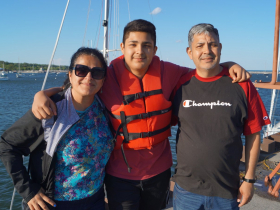 Manrique Valladares, 15, with his mom and dad at the Milwaukee Community Sailing Center on May 22, 2024. Valladares was an intern with All Hands Boatworks.