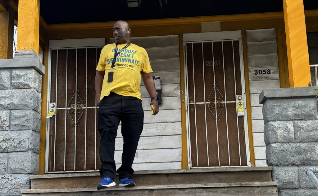 Sean Braxton with Milwaukee County knocks on door in the city’s north side. Evan Casey/WPR